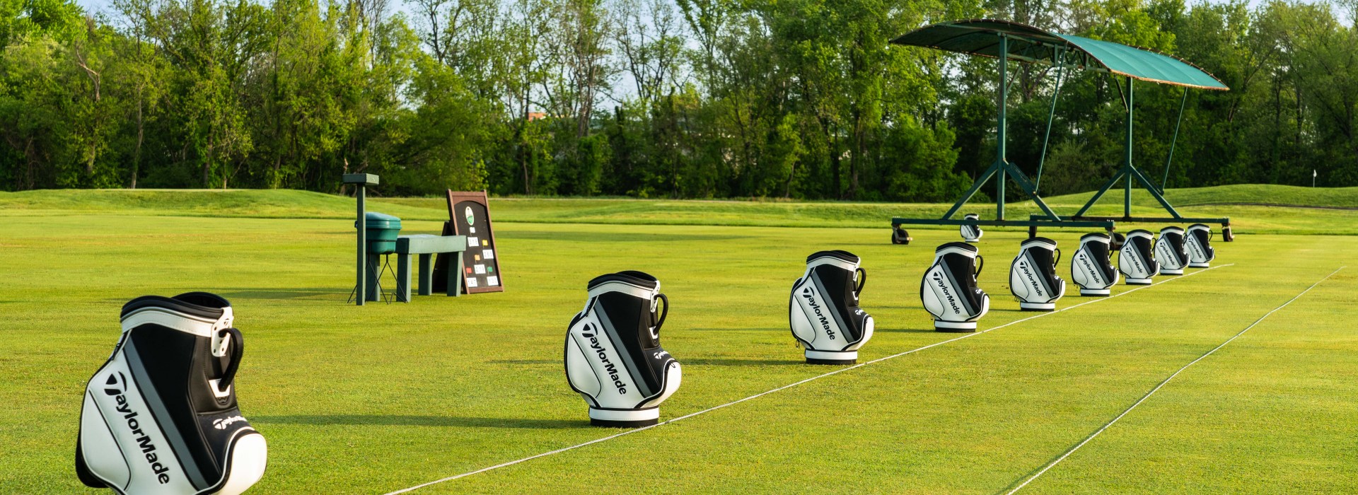 Row of golf bags on golf course range